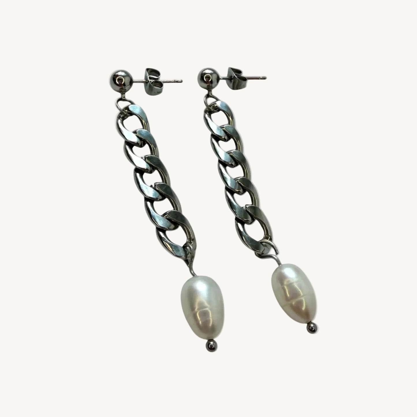 Pair of chain earrings with pearl-like beads on a white background