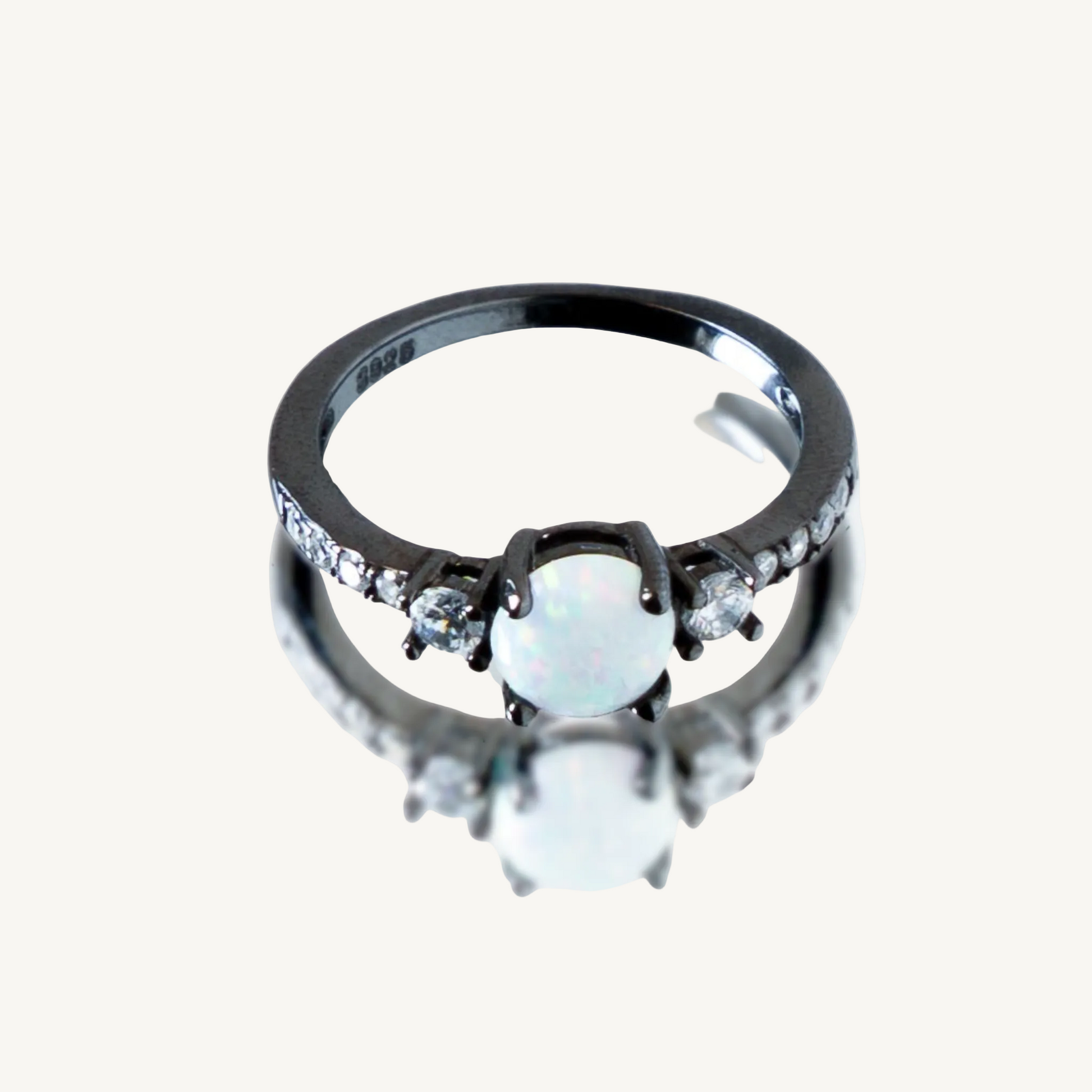 Opal, black gold-plated ring on a white background