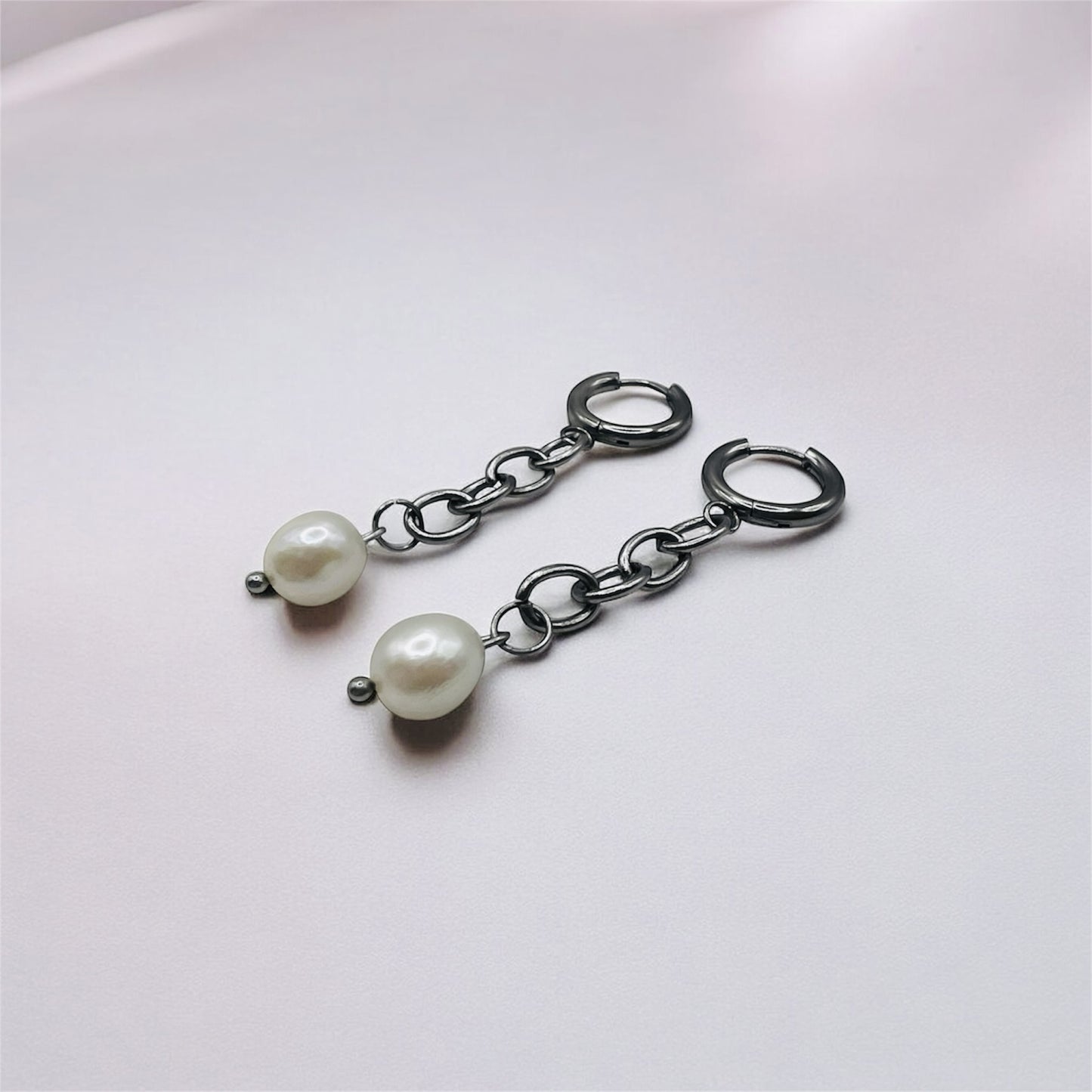 Monique - unchained silver chain earrings, naturally laying on a white background