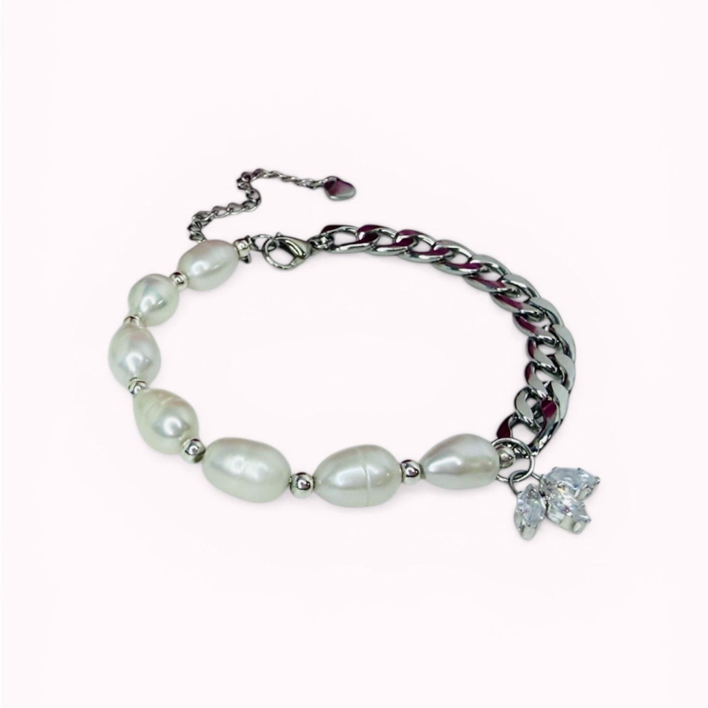 Bracelet with natural freshwater pearls and a flower looking charm on a white background