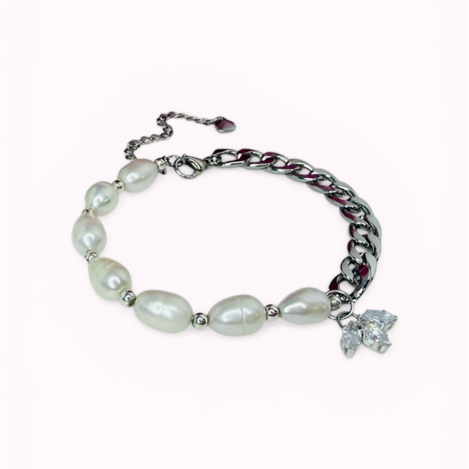 Bracelet with natural freshwater pearls and a flower looking charm on a white background