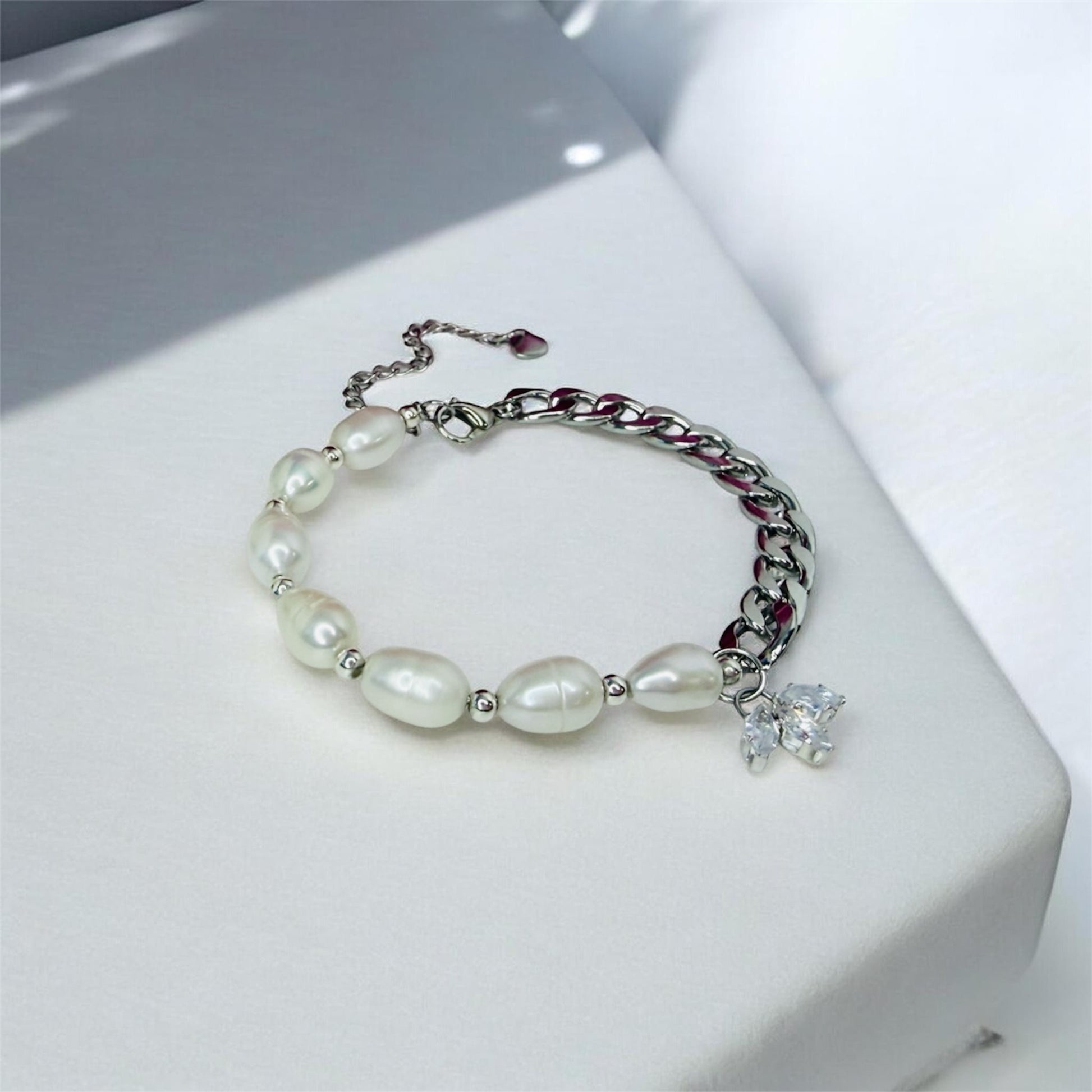 Bracelet with freshwater pearls and silver cuban chain on a white surface